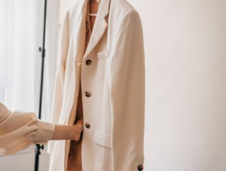 Veste de tailleur blanc pour mariée suspendue sur un portant